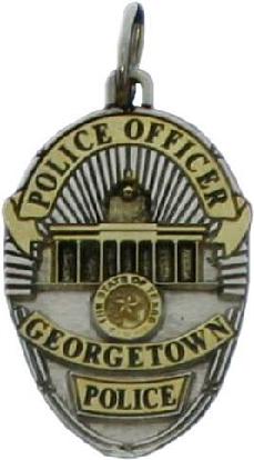 two tone sterling silver custom mini-badge jewelry pendant; oval shaped badge design of Georgetown Police Department; features antiqued building and gold plated highlights; avalable as tie tac, lapel pin, cuff links